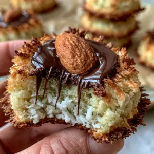 Macro close-up of an Almond Joy Cookie with a bite taken out, showing the moist snowy white coconut center. (Almond Joy Cookies)